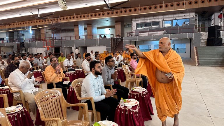 Swami addressing guests in the BAPS hall treated by PackSound
